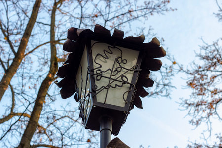 Old vintage city street lantern on blue cloudy sky background in the public place.の写真素材