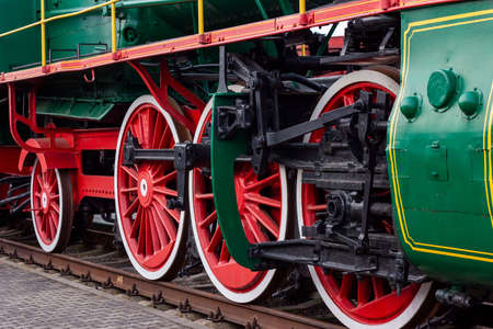 Old black and red retro steam locomotive wheels at the railway station. Vintage train staying on the railroadの写真素材
