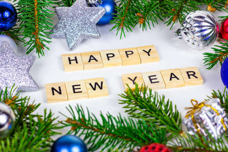Happy New Year text sign and Christmas decoration with green fir tree branches and blue and silver shiny xmas traditional balls and baubles for greeting invitation cards.の写真素材