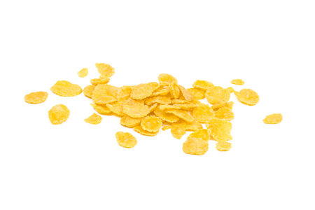 Golden yellow crunchy corn flakes cereal heap isolated on white background.