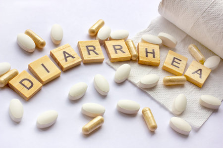 The medical phrase diarrhea on pills, capsules and tablets with toilet paper on light background....