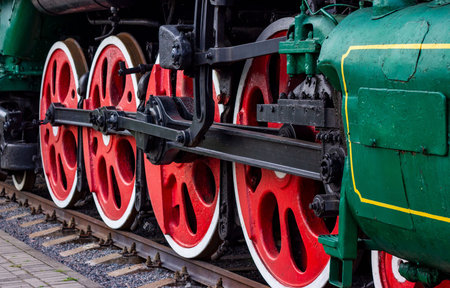 Old black and red retro steam locomotive wheels at the railway station. Vintage train staying on the...