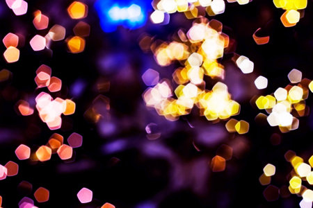 Blurred lights abstract background in the night, defocused dark glowing bokeh backdrop, magical illuminated sparkle pattern.の写真素材