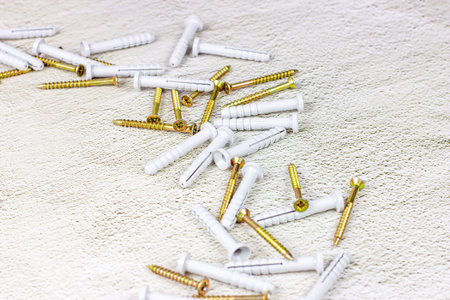 Many steel and plastic dowels for repairing on light gray cement background with copy space. DIY,...