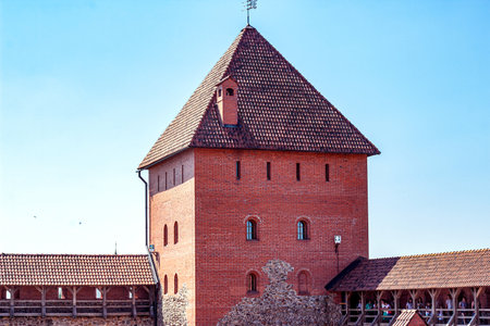 LIDA, BELARUS - JULY 10, 2021: Archeological monument medieval stone and brick Lida castle, historical show place for tourists against the blue sky in summer.のeditorial素材