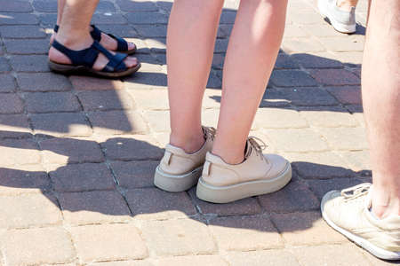 Group of caucasian young men and women legs standing in the city street and walking togeather in summer.の写真素材