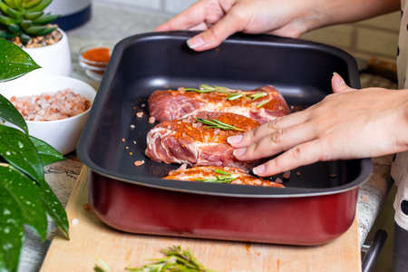 Raw marbled beef steak slices with salt and spices on metal baking dish for oven background. The preparation of a fresh meat for dinner.の写真素材