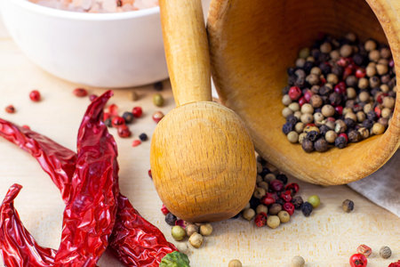 Mix of dried peppercorns in the mortar with pestle, dry chili pepper and salt for cooking on light...
