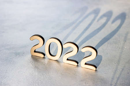 Wooden numbers 2022 silhouette with shadow on light background. New Year beginning congratulations and planning concept.の写真素材