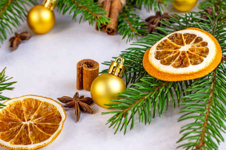 Green Christmas fir tree branches, golden baubles, dried oranges and spices as Xmas seasonal background for greeting cards. Traditional winter holidays template.の写真素材