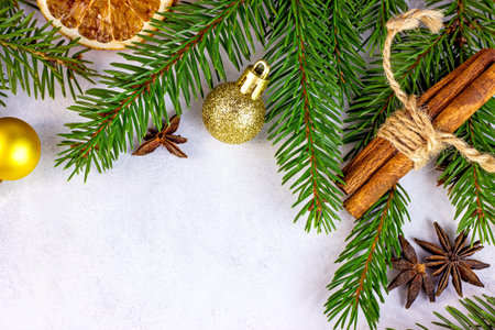 Green Christmas fir tree branches, golden baubles, oranges and spices as Xmas seasonal wreath frame on white background for greeting cards. Traditional winter holidays template with copy space.の写真素材