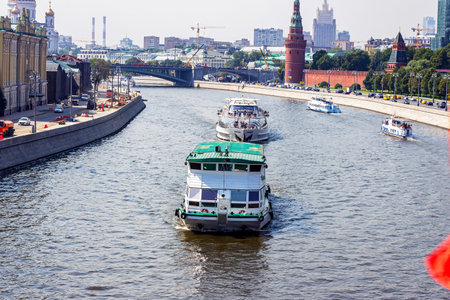 MOSCOW, RUSSIA - AUGUST 10, 2021: Tourist ships on the river on the city background.のeditorial素材