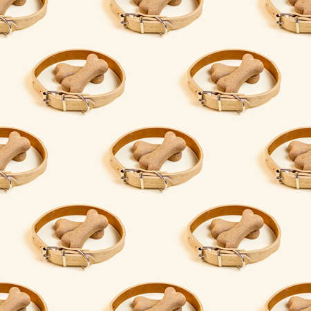 Brown biscuit bones for dogs in a beige collar repeat seamless pattern on light background. Dog and puppy food, healthy treats wrapping paper.の写真素材