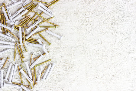 Many steel and plastic dowels for repairing on light gray cement background with copy space. DIY,...