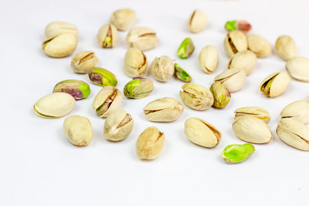 Roasted salted pistachio nuts in nutshell on light background.
