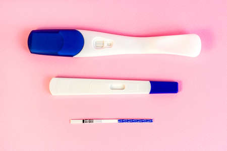 Different types of new pregnancy tests for woman on light pink background.の写真素材
