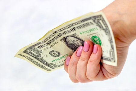 One usa dollar paper bills currency in Caucasian woman hands on light background. Money, tips and...