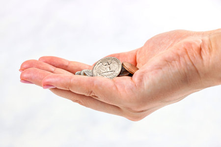 Usa coins in Caucasian woman hands on light background. Money, tips and savings concept.