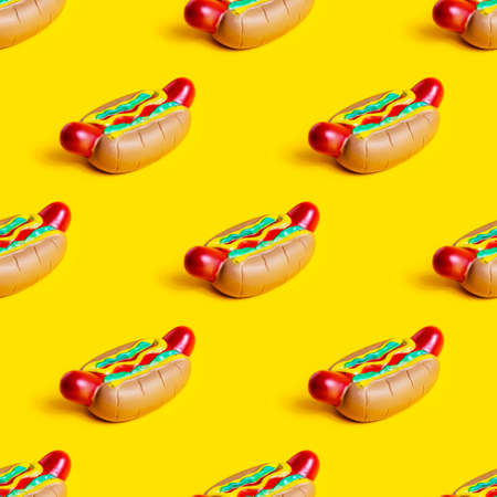 Toy American rubber hot dog repeat seamless pattern on bright yellow background.の写真素材