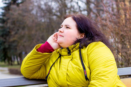 Happy attractive chubby overweight Caucasian woman smiling portrait outdoors. Cheerful pretty body positive person laughing during walk in the park.の写真素材