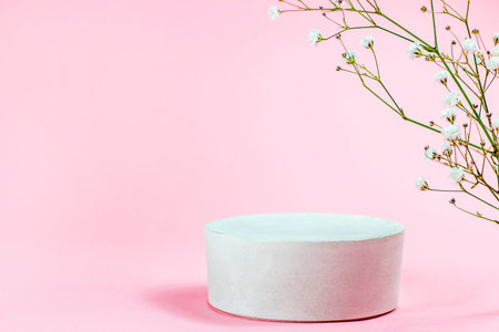 White empty round podium with platform for product presentation on soft pastel pink background....