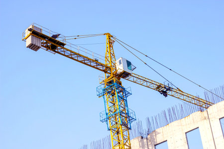 High crane for house building at the construction site on blue sky background.の写真素材