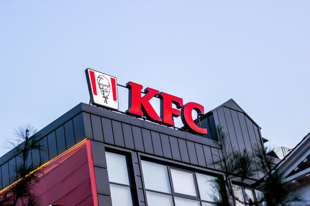 DUSHANBE, TAJIKISTAN - JULY 28, 2022: Red KFC fast food restaurant logo with Colonel Sanders against...