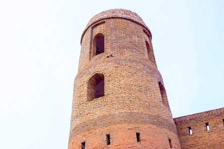HISOR, TAJIKISTAN - JULY 31, 2022: Ancient Hissar fortress tower exterior in summer against the blue sky.のeditorial素材