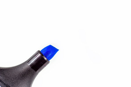Black marker pen with bright blue tip on light background close up with copy space.
