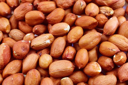 Raw unpeeled peanut nuts texture close up.