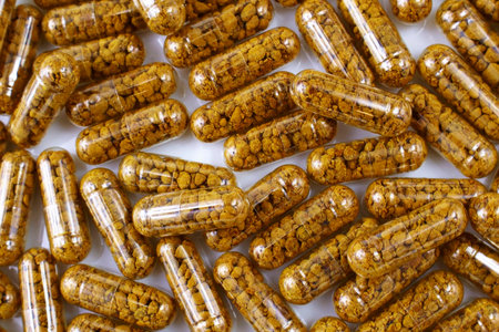 Top view of nutritional supplement capsules with bee pollen inside close up.の写真素材