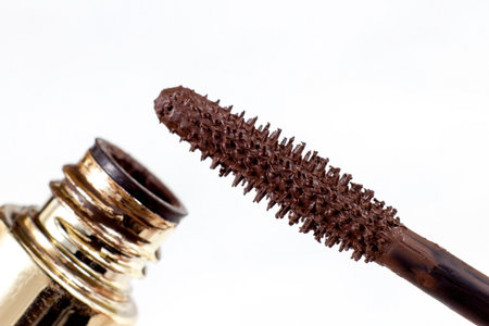 Brown mascara brush applicator with the tube on light background close up.の写真素材