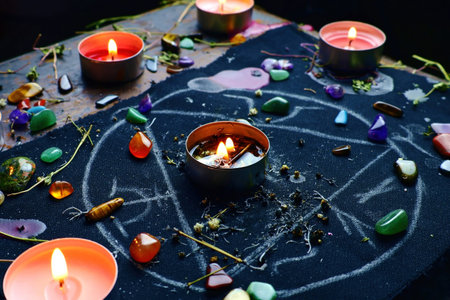 Black magic ritual background with magical altar, candles, crystals and herbs. Sorcerer rite of...