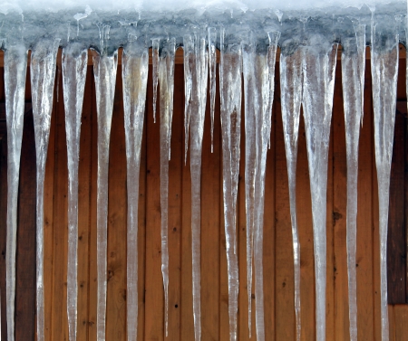 icicles on a wooden wall backgroundの写真素材