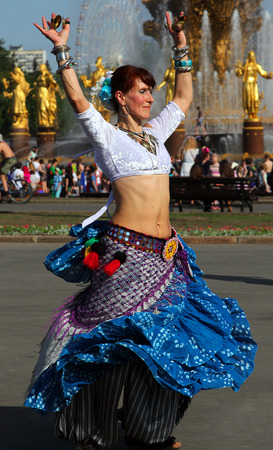 MOSCOW, RUSSIA - MAY 18, 2014: Beautiful woman dansing at Cosplay festival on a background of the fountain Friendship of Nations at the All-Russia Exhibition Center in Moscowのeditorial素材