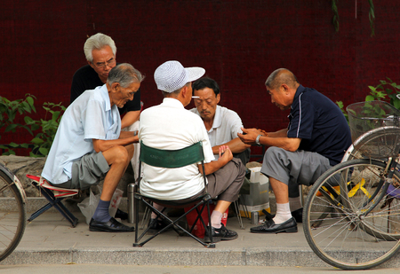 BEIJING, CHINA - JUL 5, 2011: Chinese men playing mahjong (or majiang, very popular chinese game) in Jingshan park, not far from Forbidden Cityのeditorial素材