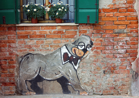 VENICE, ITALY - APR 15, 2013: A dog in a bow tie - old graffiti on the wall of a brick house in Castello districtのeditorial素材