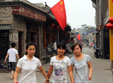 BEIJING, CHINA - JUL 4, 2011: Chinese girls at Yandan (Pipe) hutong. This ancient street is very popular tourist sight situated between Shichahai area and Drum Towerのeditorial素材
