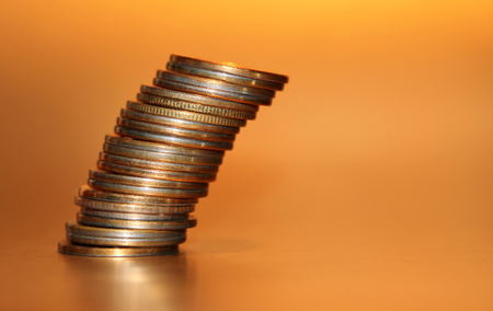 Falling stack of coins on a golden backgroundの写真素材