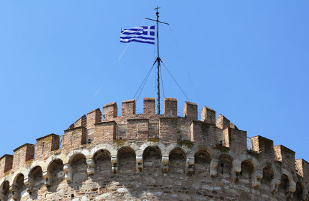 Greek flag on top of White Tower of Thessaloniki, Greece