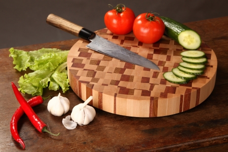 the knifed cucumber, tomatoes, Chile, salad, and garlic on a chopping boardの写真素材