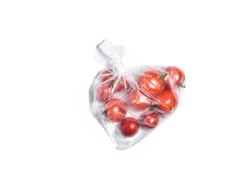 Fresh red vine tomatoes in transparent plastic bag isolated on white top viewの写真素材