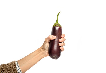 Woman's hand holds eggplant isolated on white backgroundの写真素材