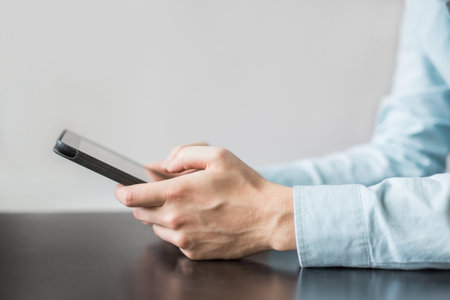 Man's hands with the tablet. Person sitting on the table searching the web or reading