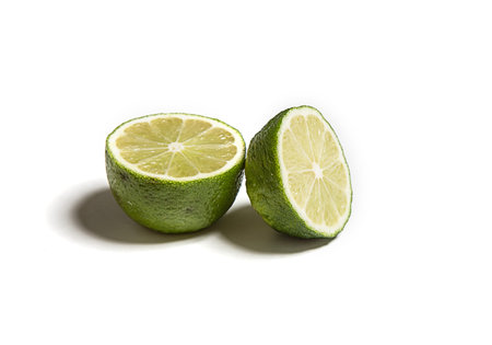 Sliced or cut lime isolated on white. Fresh citrusの写真素材