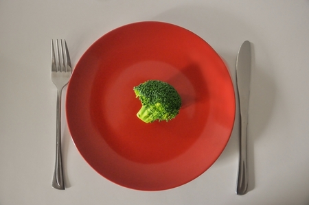a red plate with fresh broccoli on itの写真素材