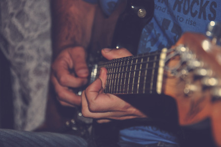 sitting man playing on electric guitarの写真素材