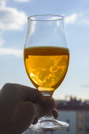 a glass of yellow cold beer in handの写真素材
