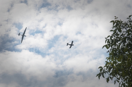 a glider hauled by plane over the treesの写真素材