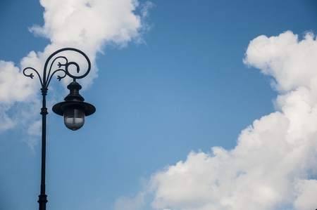 an antique street lamp against blue skyの写真素材